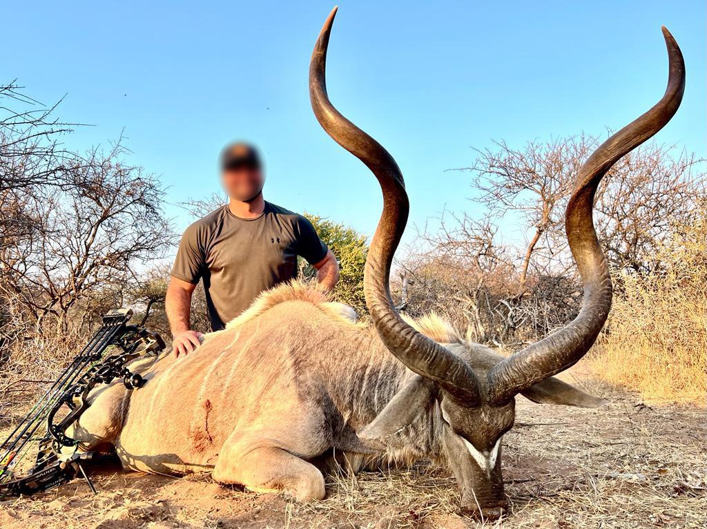Bow hunter with a kudu bull and his compound bow