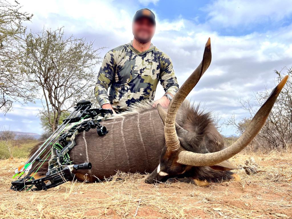 Bow hunter with a kudu bull and compound bow