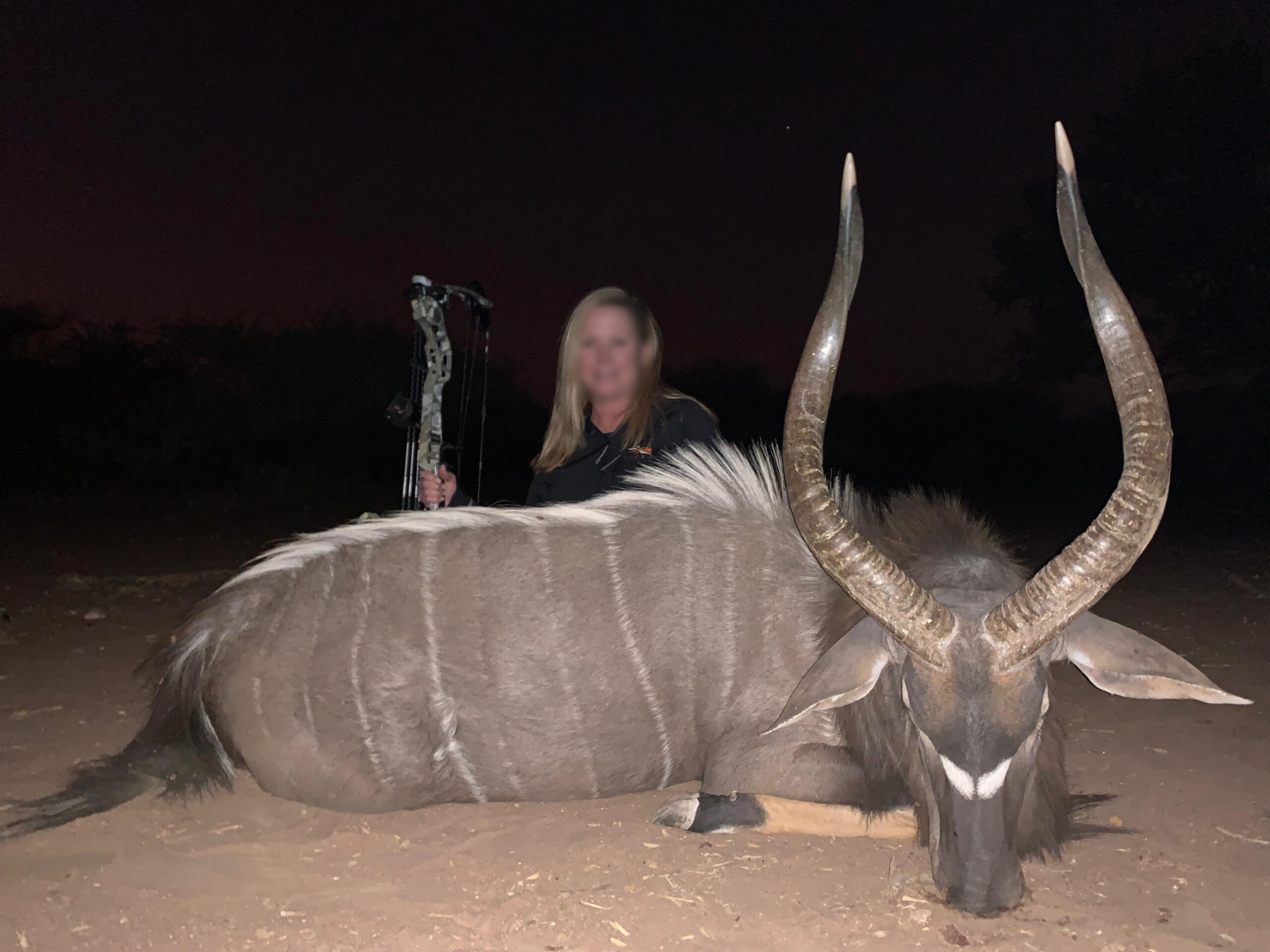 Bow hunter with a kudu bull taken after dark