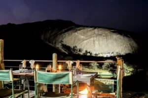 Candlelit dinner tables below a granite dome at night