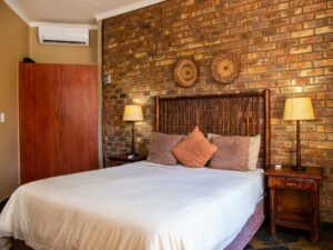 Double bedroom with a face-brick wall and woven baskets