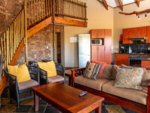 Self-catering chalet lounge and kitchen with a wooden staircase