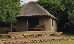 Thatched guest chalet with a stone-edged terrace