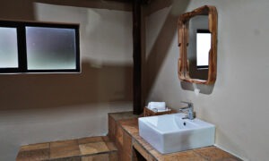 Basin with a wooden mirror in an en-suite bathroom