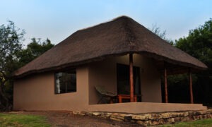 Thatched guest chalet with a covered veranda