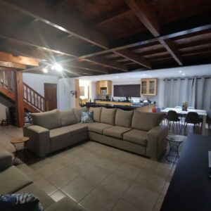 Lounge with a large corner couch and staircase