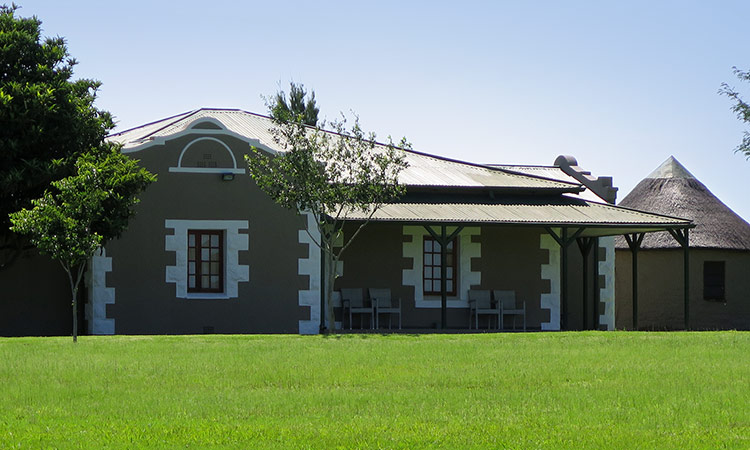 Lodge building with a veranda across a green lawn