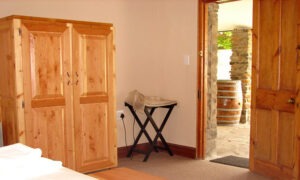 Bedroom with a wooden wardrobe and door onto the garden
