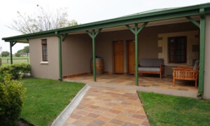 Covered veranda with a paved path and garden