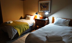 Twin bedroom with bedside lamps at the lodge