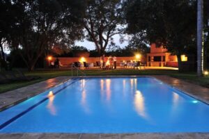 Lit swimming pool and lodge buildings at night